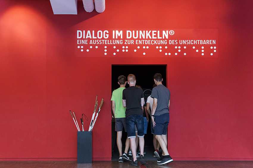 Gruppe betritt Eingang in die Ausstellung "Dialog im Dunkeln"